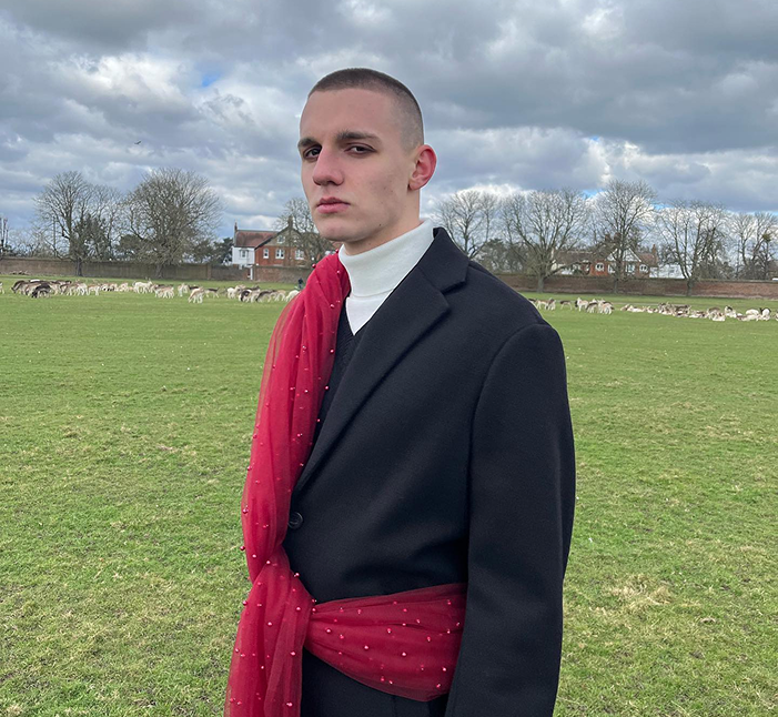 Man wearing a black suit with a red scarf 